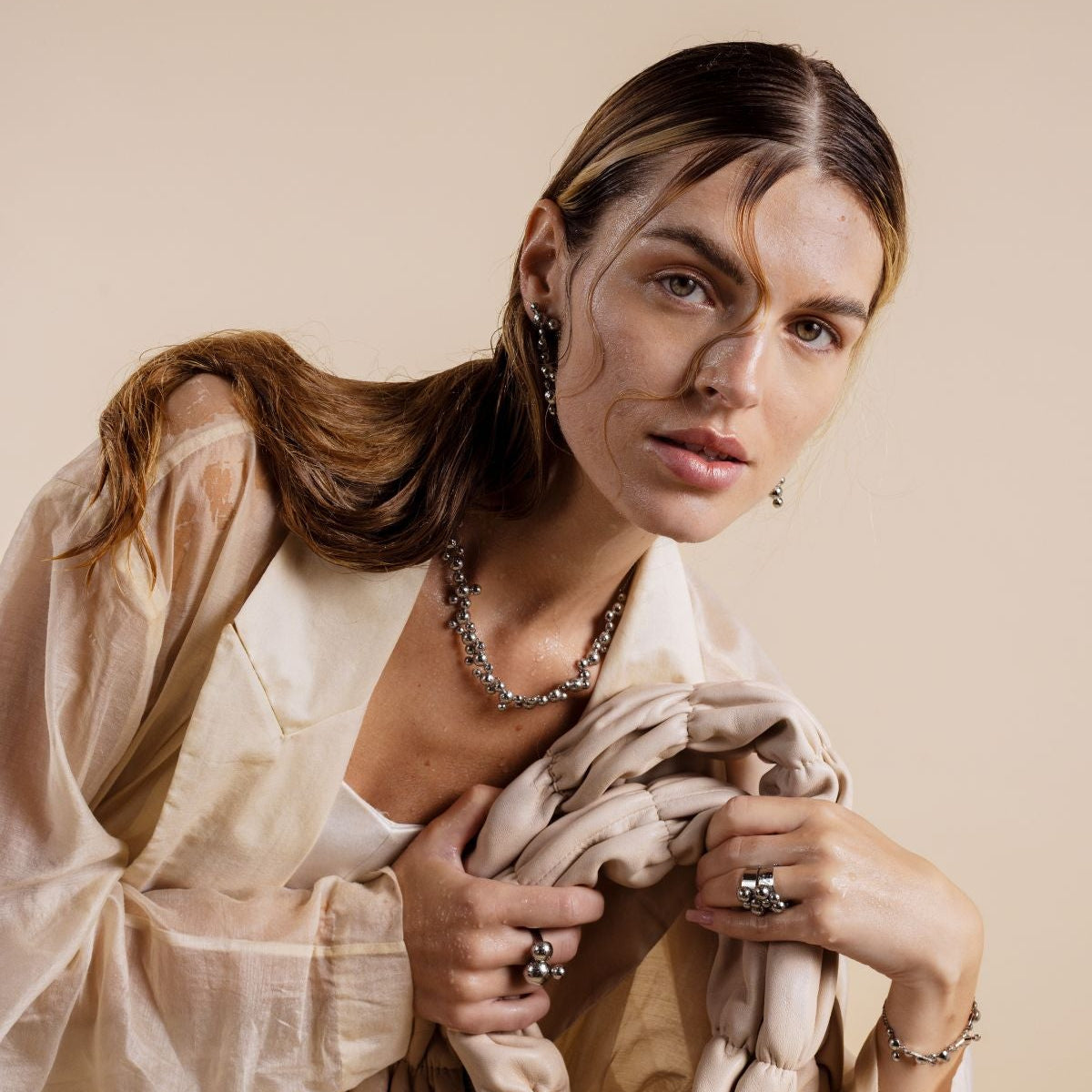 Woman holding a textured fabric against a beige background