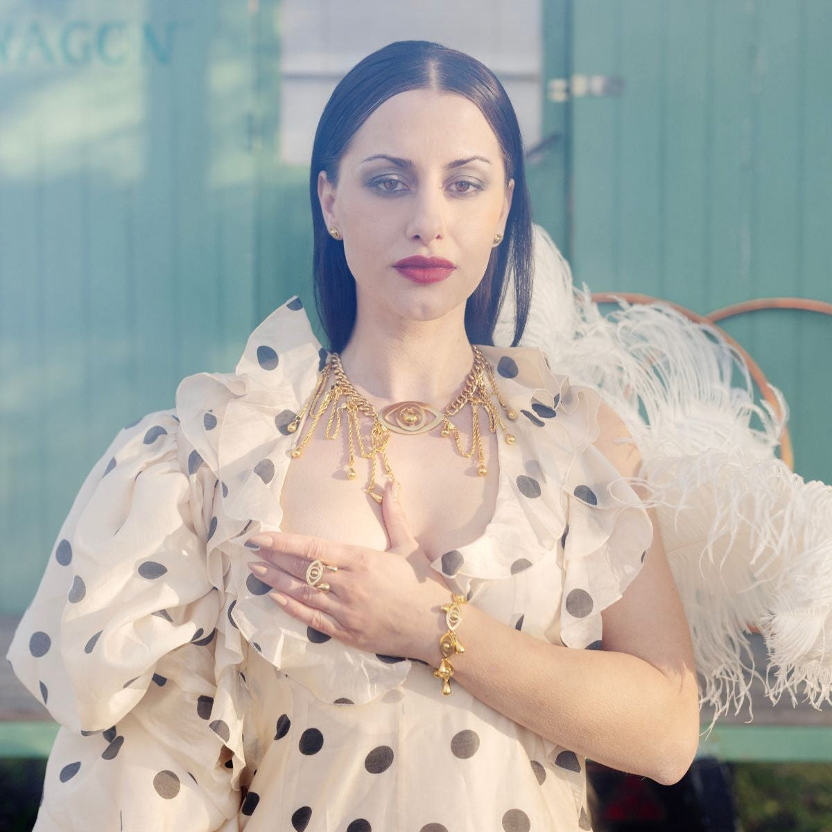 Woman wearing a polka dot dress with ruffled sleeves in front of a blurred background